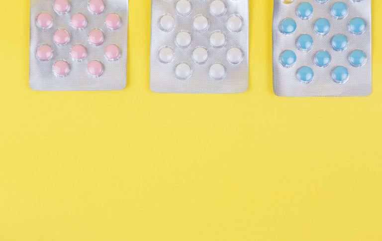 Blisterpackung mit Tabletten vor gelben Hintergrund